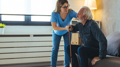 Young caring nurse helping senior old elderly man grandfather wa