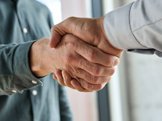 Two happy professional businessmen shaking hands at meeting. Handshake