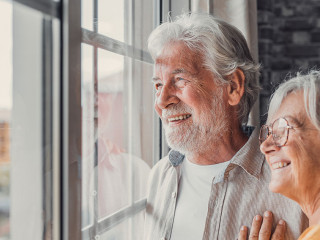 Happy bonding loving middle aged senior retired couple standing
