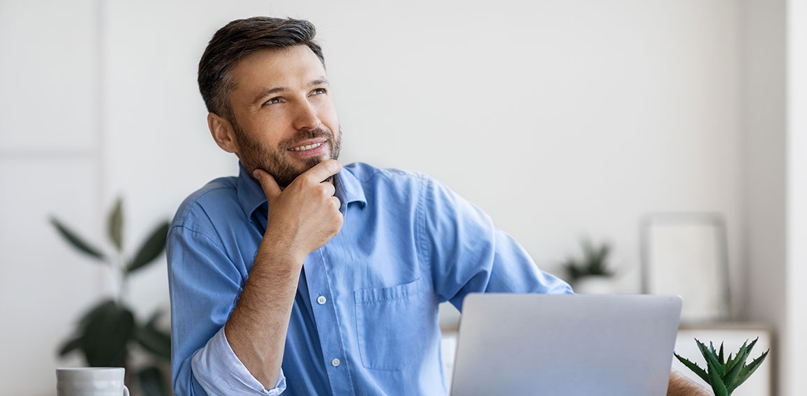Handsome Male Entrepreneur Sitting At Workplace With Thoughtful Face Expression