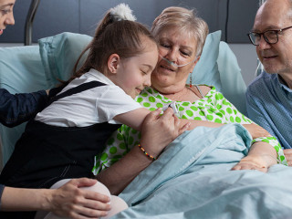 Little girl greeting grandmother with hug at hospital