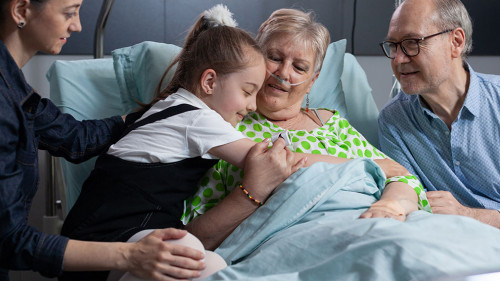 Little girl greeting grandmother with hug at hospital