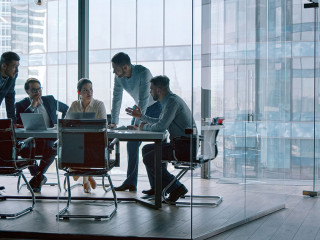 Group of business people working with technology at a meeting in a conference room