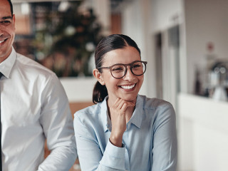 Three smiling coworkers talking together in an office