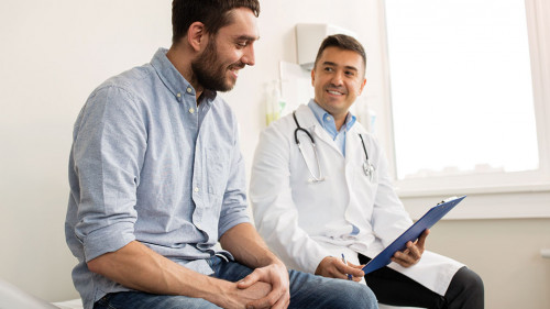 smiling doctor and young man meeting at hospital