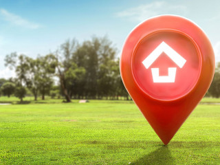 House symbol with location pin icon on earth and green grass in