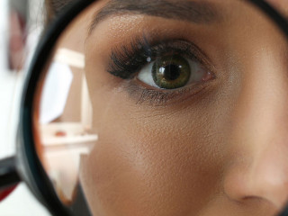 Funny smiling businesswoman hold in arm magnifier