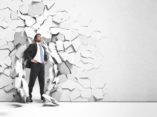 businessman breaking trough a wall