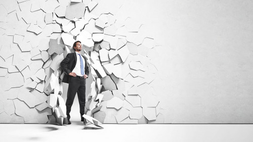 businessman breaking trough a wall