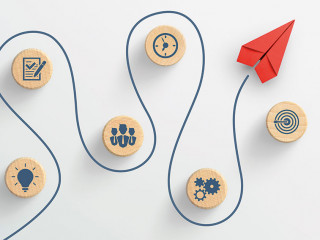 Red paper plane and wooden cubes with business strategy icons on