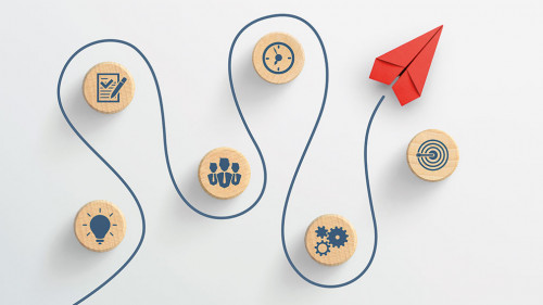 Red paper plane and wooden cubes with business strategy icons on