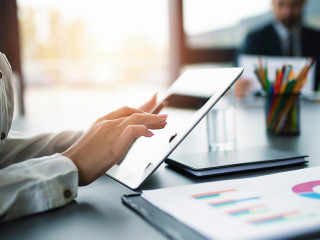 Businesswoman works in office with a tablet.