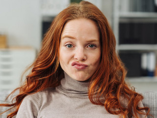 Pretty young redhead woman pulling a face