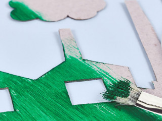 Greenwashing concept with cardboard factory being painted green