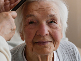 Unrecognizable female expressing care towards an elderly lady, b