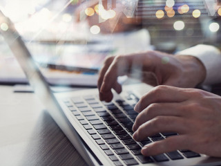 Business man works in office with laptop in the foreground. Concept of teamwork and partnership. double exposure
