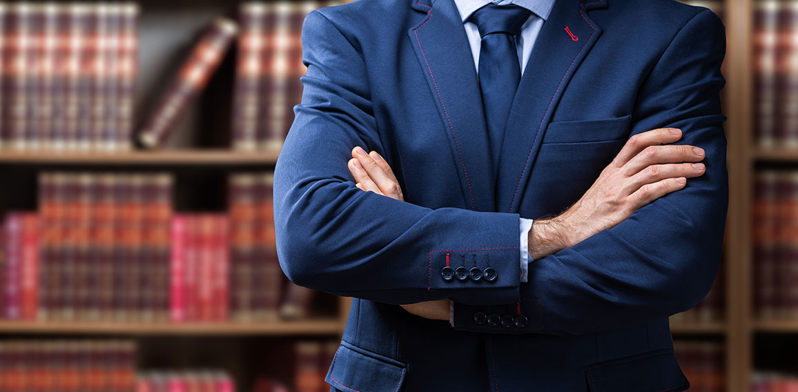 Midsection Of Lawyer Standing Against Bookshelf
