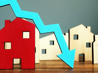 The crisis in the real estate market. Falling home value. Property and downward arrow.