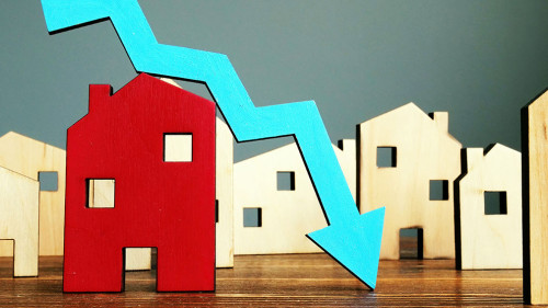 The crisis in the real estate market. Falling home value. Property and downward arrow.