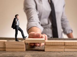 Little businessman walking across bridge