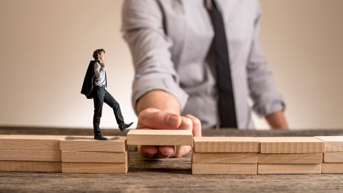 Little businessman walking across bridge