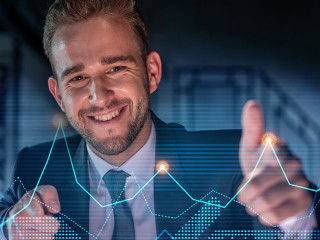 Portrait of handsome businessman in formal suit thinking how to optimize trading strategy at corporate finance fund. Forex chart hologram over modern office background