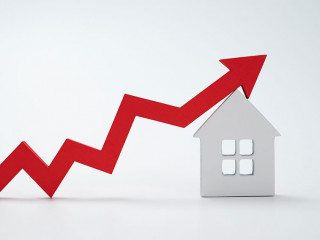 a red up arrow and house. The concept of the rising price of real estate
