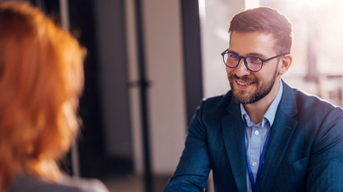 Happy bank manager shaking hands with a client after successful agreement in the office.