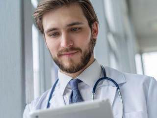 male medical doctor using tablet computer in hospital.