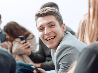 smiling guy sitting in a circle at a group meeting