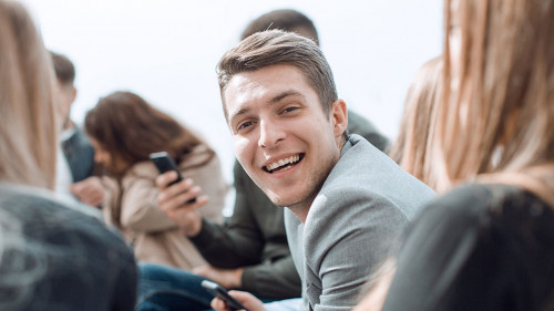 smiling guy sitting in a circle at a group meeting