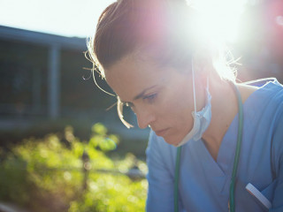 tired modern medical doctor woman sitting outside near clinic
