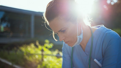 tired modern medical doctor woman sitting outside near clinic
