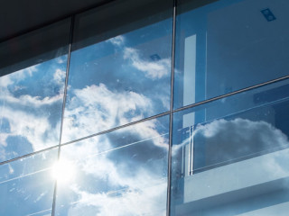 Sun ray and blue sky reflection on window office building, Busin