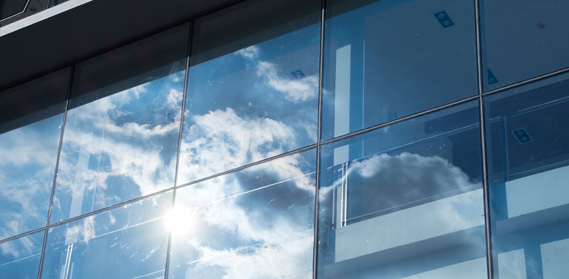 Sun ray and blue sky reflection on window office building, Busin