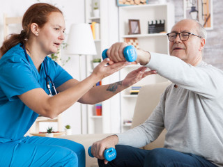 Senior man in nursing home with doing physical therapy
