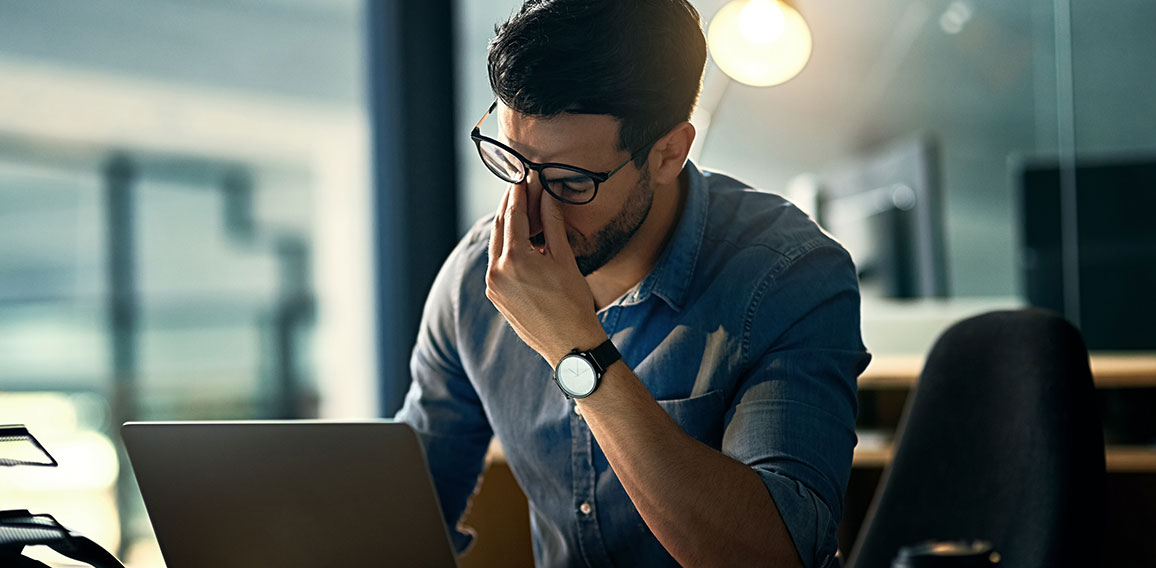 Burnout is killing his career. Shot of a young businessman experiencing stress during a late night at work.