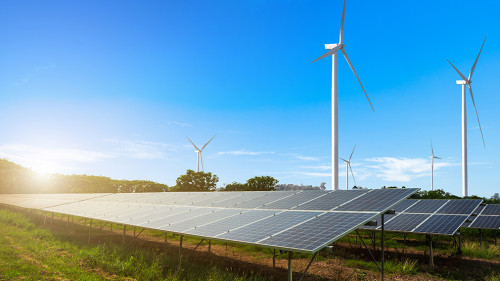 solar panels with wind turbines against mountanis landscape agai