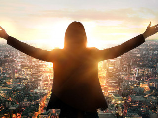 Young woman looking at the City of London at sunset. Planning th