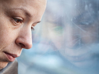 Frau-nachdenklich-Fenster-103351766-AS-marjan4782