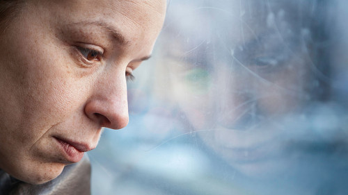 Frau-nachdenklich-Fenster-103351766-AS-marjan4782