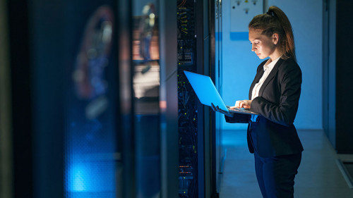 Female engineer working in server room at modern data center