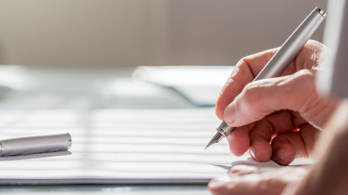 Businessman writing on a document