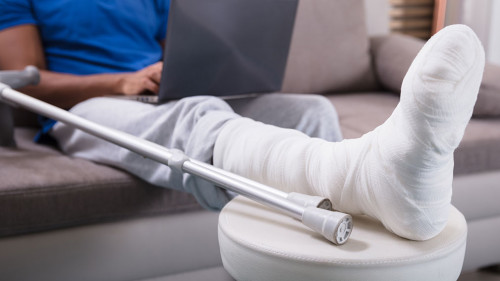 Man With Broken Leg Using Laptop