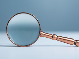 Close up magnifier glass on wooden table, the concept of searching or finding for an idea, Search for information, Find the answer.