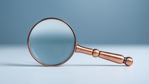 Close up magnifier glass on wooden table, the concept of searching or finding for an idea, Search for information, Find the answer.