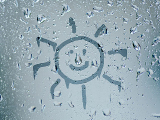 sun sign on natural water drops on glass window background