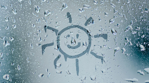 sun sign on natural water drops on glass window background