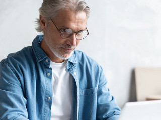 Middle-aged man working from home-office on laptop.