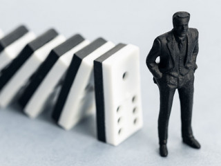 Domino effect concept. Dominoes falling and putting a company or